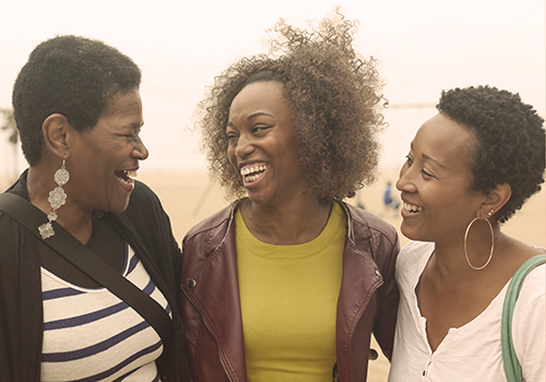 African American mother, daughter and grandmother at the beach after shopping together